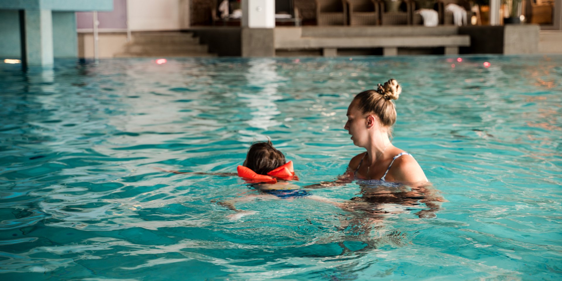 Schwimmlehrerin mit Kind beim Schwimmkurs