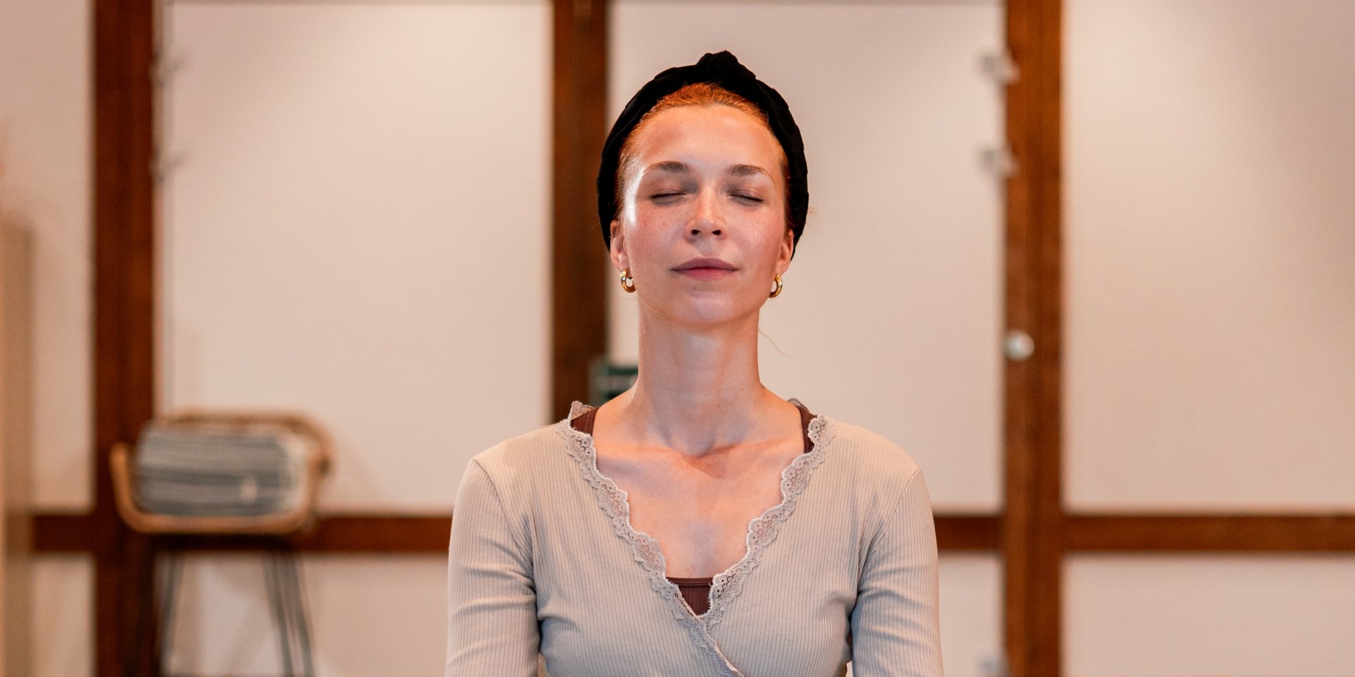 Eine Frau in Meditationshaltung auf einer Yoga-Matte im hellen Kursraum des Hotels Vier Jahreszeiten am Schluchsee.