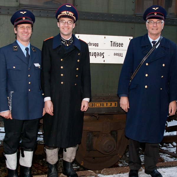 Personal in historischen Uniformen vor der Museumsbahn im Schwarzwald.