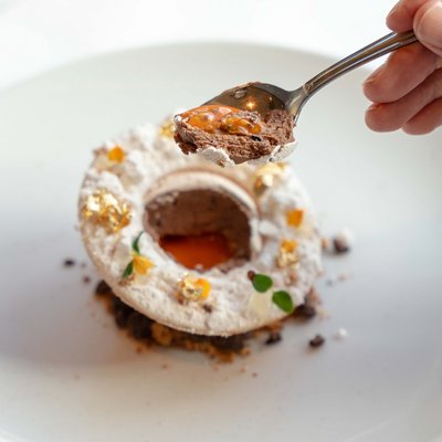 Ein Koch richtet ein filigranes Dessert mit der Pinzette im Hotel Vier Jahreszeiten am Schluchsee an.