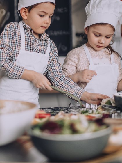 Kinder kochen, im Vordergrund sind verschiedene Zutaten