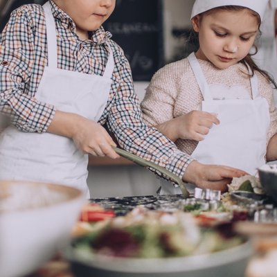 Kinder kochen, im Vordergrund sind verschiedene Zutaten