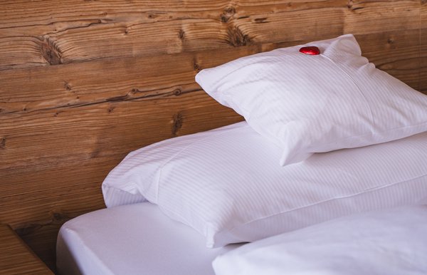 Einladendes Schlafzimmer mit Holzverkleidung, gemütlicher Beleuchtung und alpinem Flair.