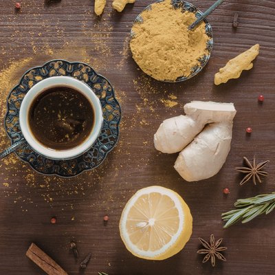 Tee umgeben von verschiedenen Gewürzen