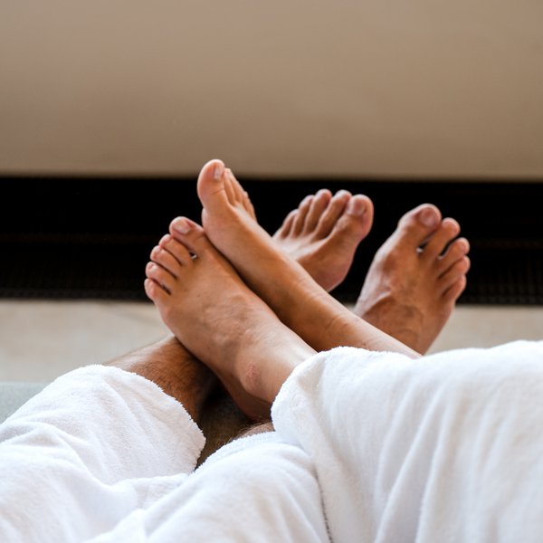 Nahaufnahme der Füße zweier Gäste in der entspannten Atmosphäre des Wellnessbereiches vom Vier Jahreszeiten Hotel am Schluchsee.
