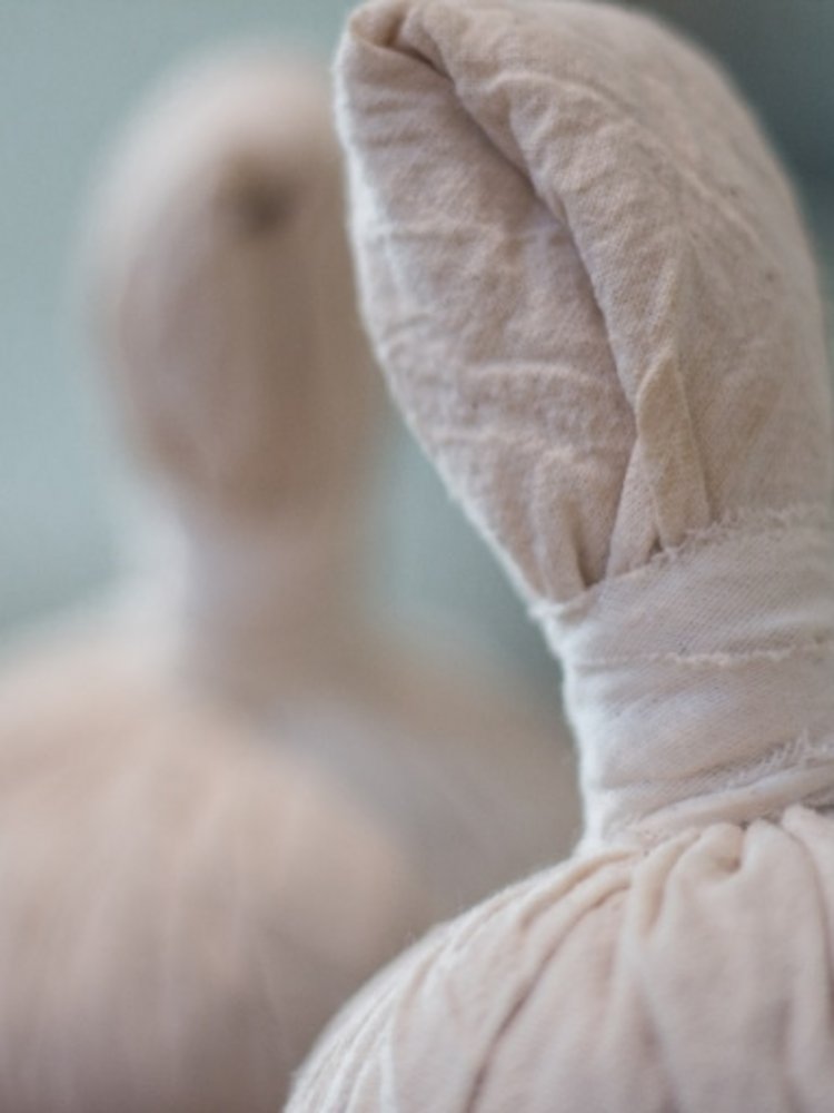 Nahaufnahme von zwei handgefertigten Kräuterstempeln, die für Wellness-Massagen im Hotel Vier Jahreszeiten am Schluchsee bereitliegen.