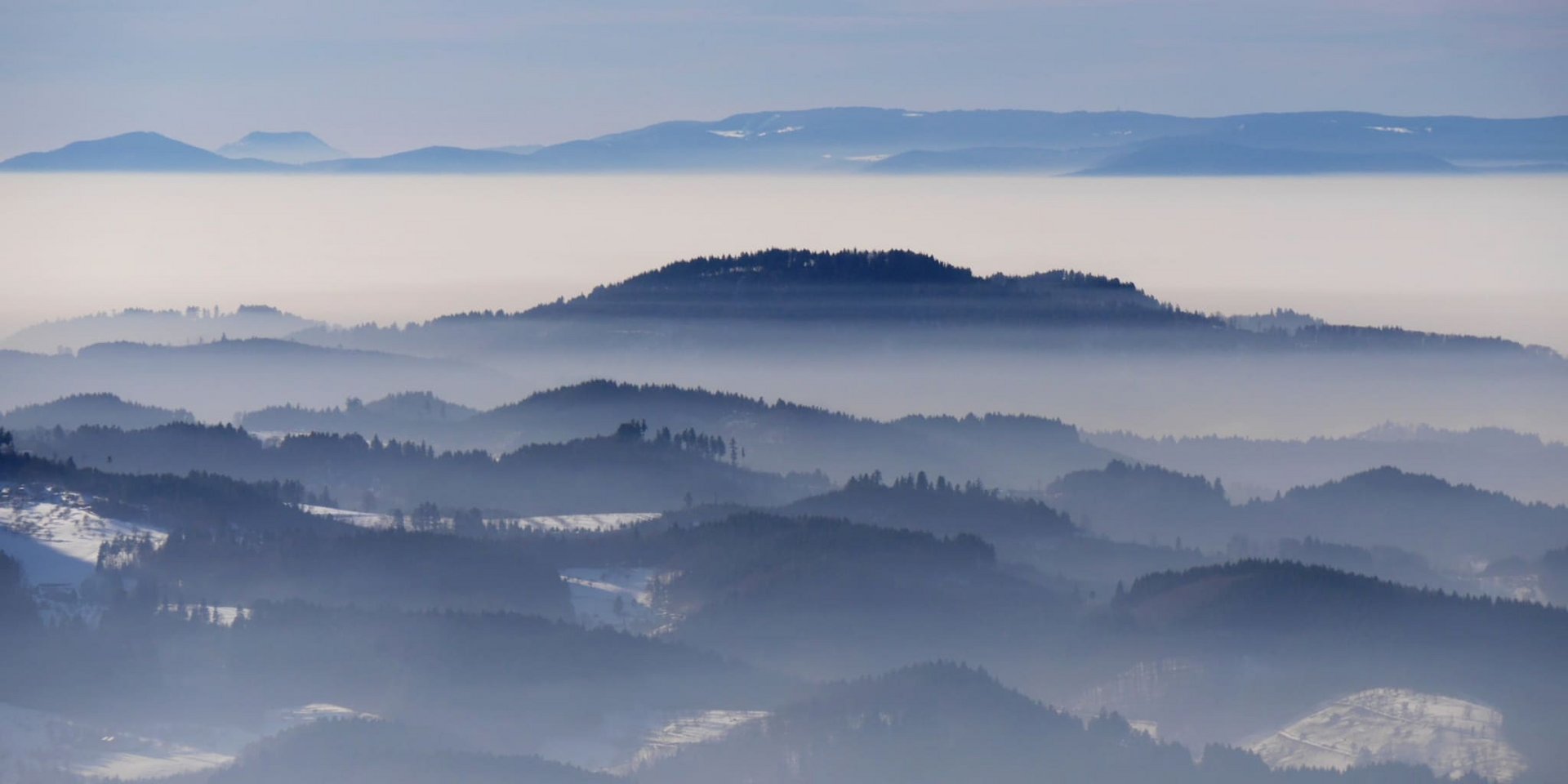 Malerischer Ausblick auf die blau schimmernden Bergketten des Schwarzwalds im winterlichen Abendlicht.