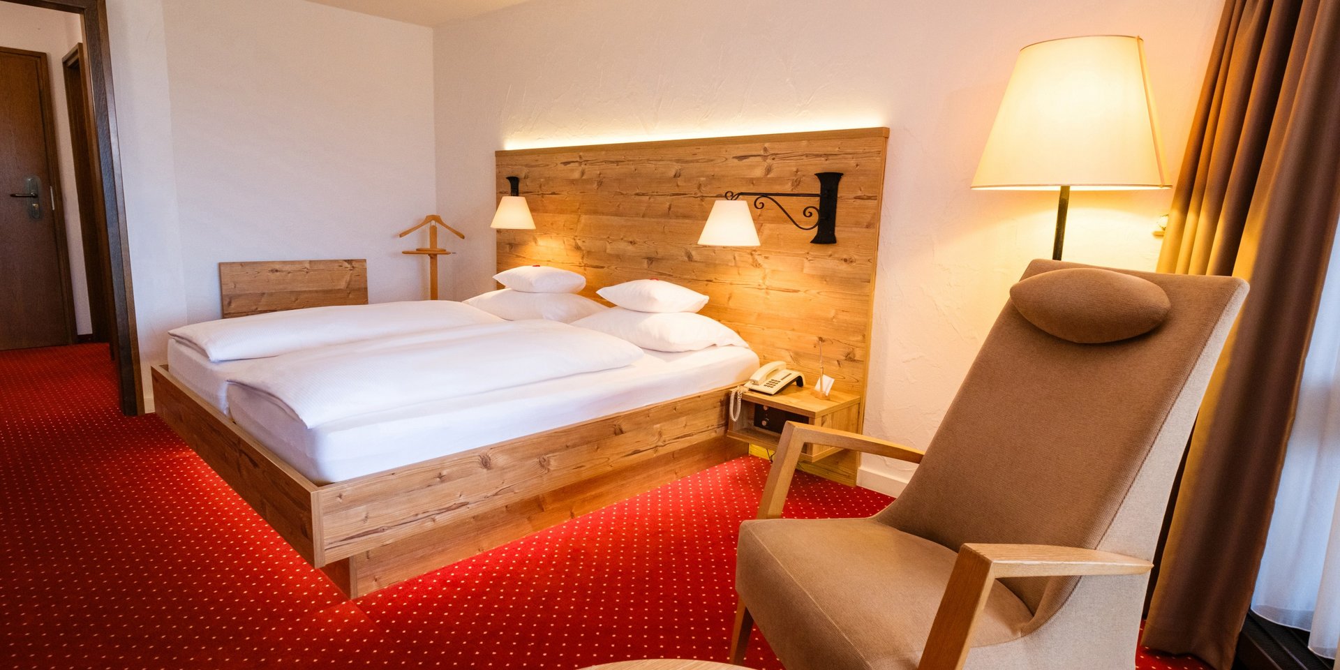 Hell gestalteter Schlafbereich mit Leseecke im Hotel Vier Jahreszeiten am Schluchsee.