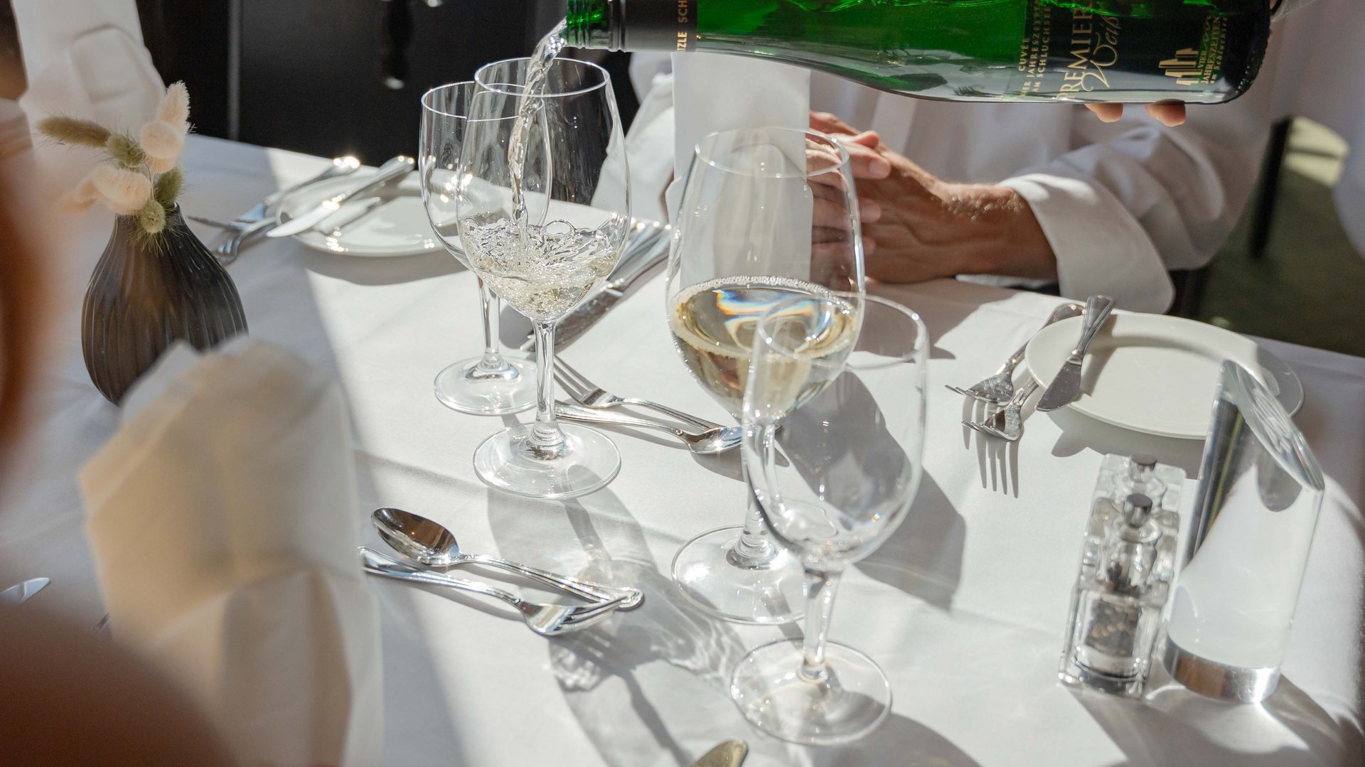 Ein Sommelier schenkt Weißwein für Gäste im Panorama-Restaurant des Hotels Vier Jahreszeiten am Schluchsee ein.