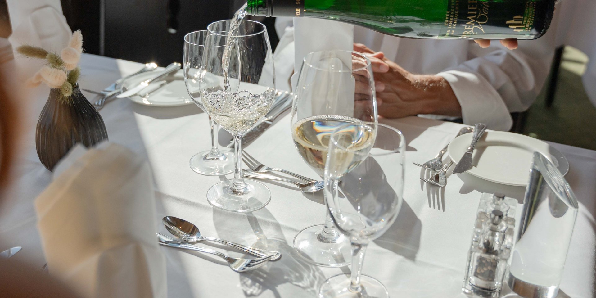 Ein Sommelier schenkt Weißwein für Gäste im Panorama-Restaurant des Hotels Vier Jahreszeiten am Schluchsee ein.