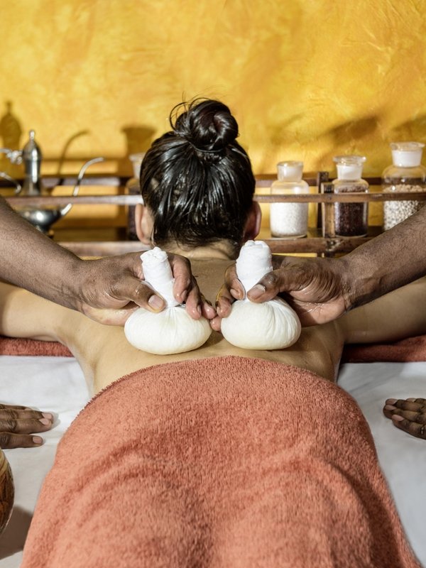 Zwei Therapeuten führen gleichzeitig eine ayurvedische Stempelmassage im Hotel Vier Jahreszeiten am Schluchsee durch.