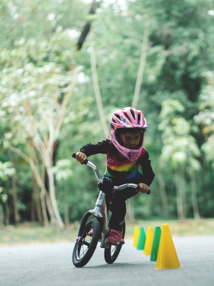 Ein Kind übt Geschicklichkeit mit dem Fahrrad zwischen Pylonen auf dem Gelände des Hotels Vier Jahreszeiten.