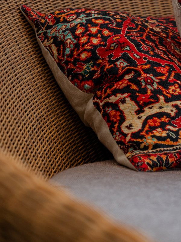 Detailaufnahme eines gemütlichen Sessels mit dekorativem Kissen im Wellnessbereich des Hotels Vier Jahreszeiten.