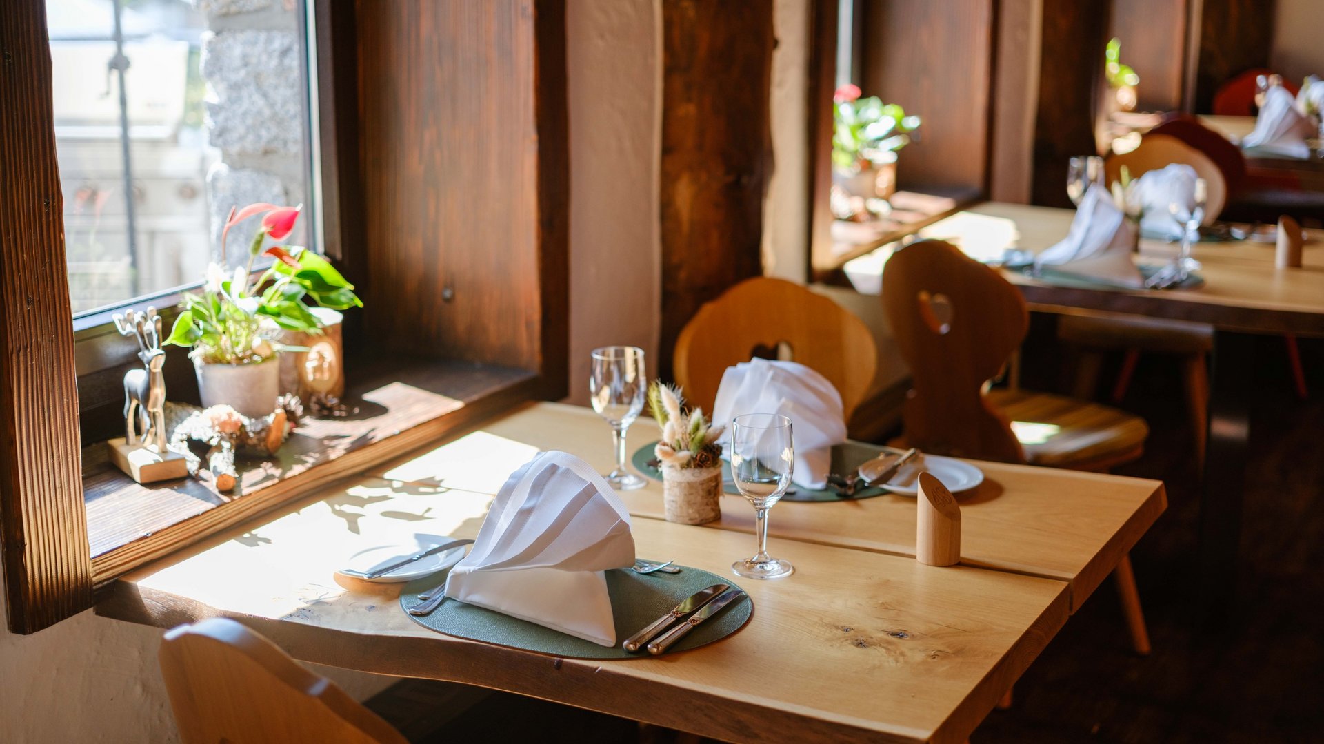 Lichtdurchfluteter Fensterplatz mit herrlicher Aussicht und alpiner Dekoration im Hotel Vier Jahreszeiten am Schluchsee.