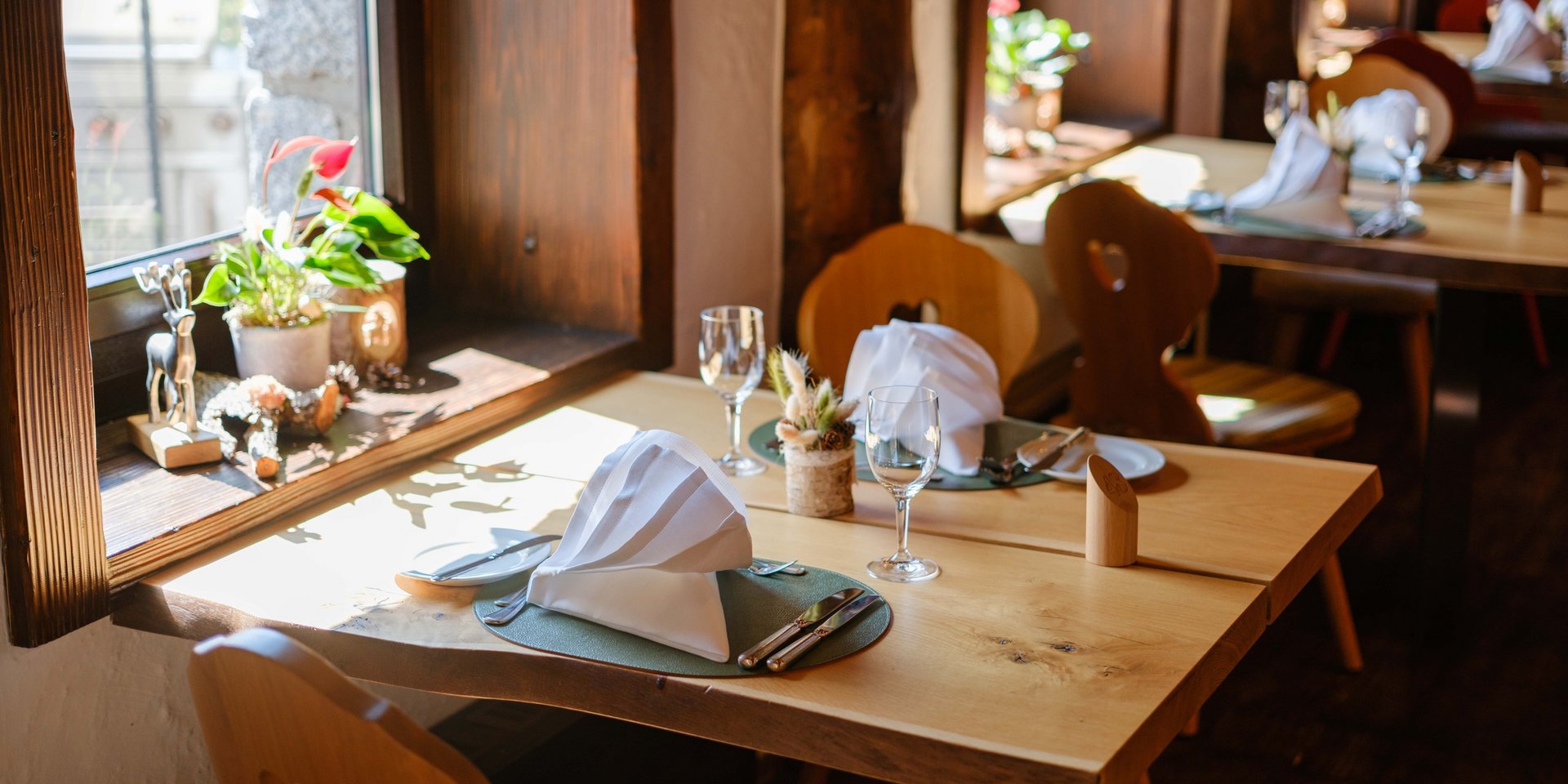 Lichtdurchfluteter Fensterplatz mit herrlicher Aussicht und alpiner Dekoration im Hotel Vier Jahreszeiten am Schluchsee.