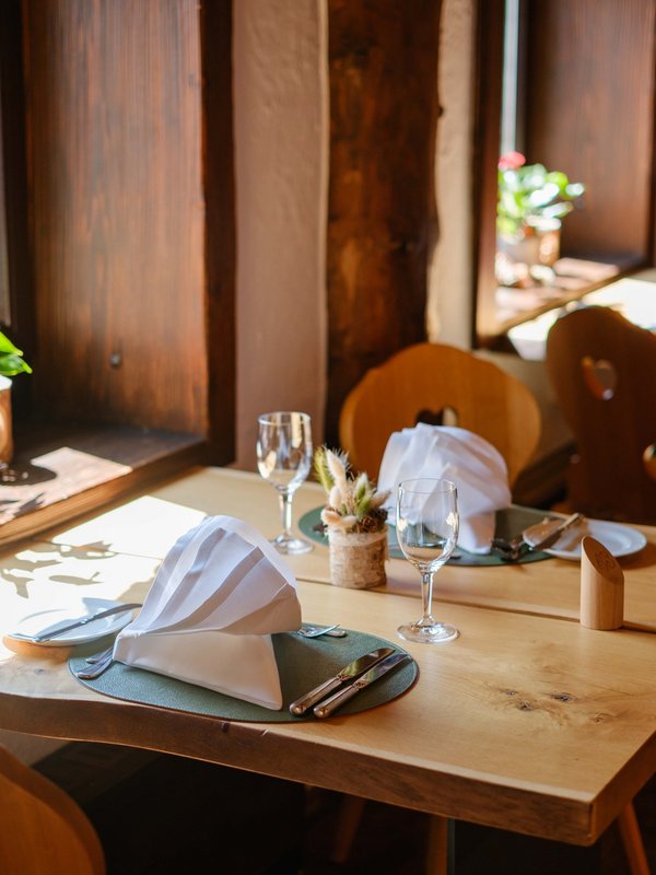Lichtdurchfluteter Fensterplatz mit herrlicher Aussicht und alpiner Dekoration im Hotel Vier Jahreszeiten am Schluchsee.