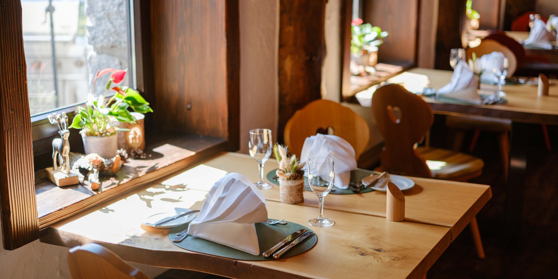 Lichtdurchfluteter Fensterplatz mit herrlicher Aussicht und alpiner Dekoration im Hotel Vier Jahreszeiten am Schluchsee.