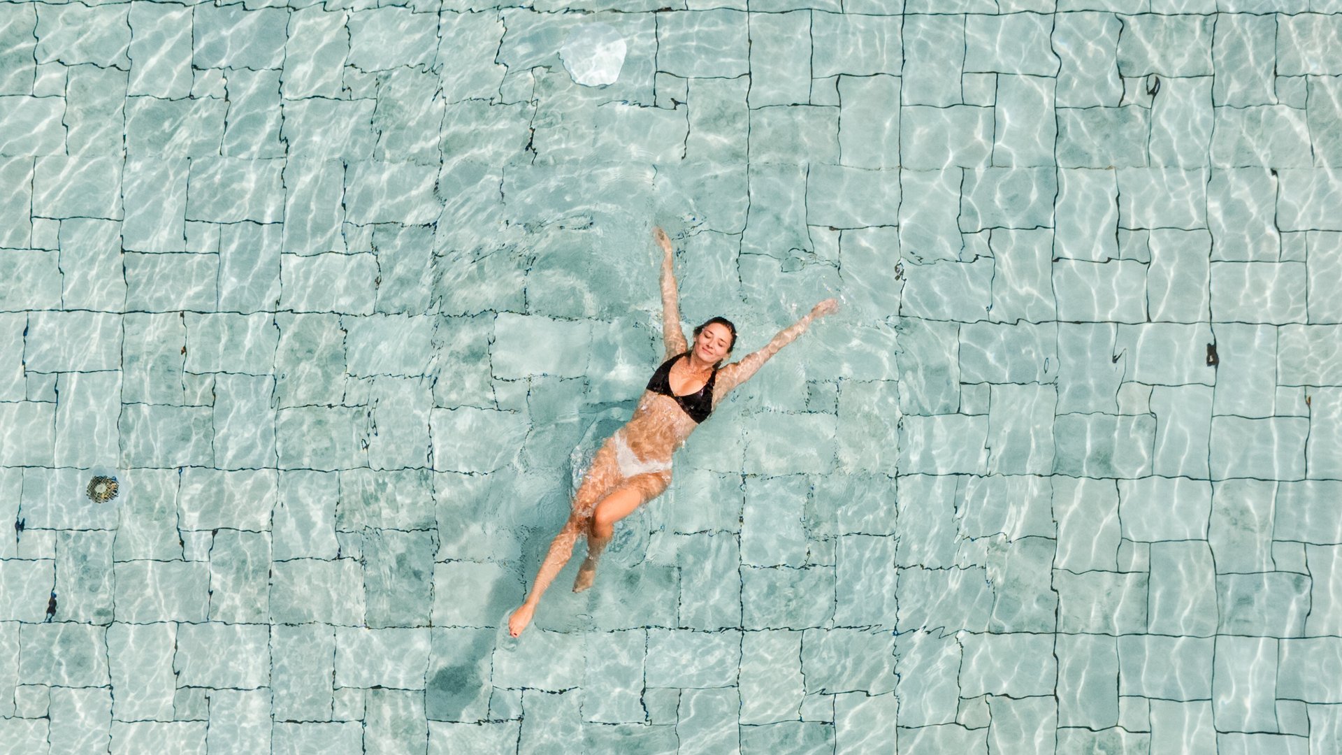 Frau auf dem Rücken schwimmend im Pool