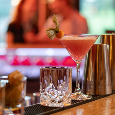 Zwei frisch zubereitete, farbenfrohe Cocktails stehen bereit an der stilvoll beleuchteten Bar des Hotels Vier Jahreszeiten am Schluchsee.