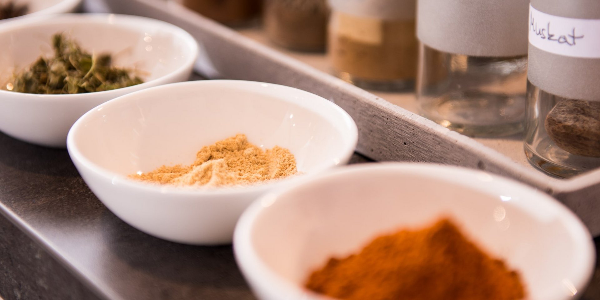 Verschiedene Pulvergewürze in weißen Schalen für die ayurvedische Küche im Hotel Vier Jahreszeiten am Schluchsee.