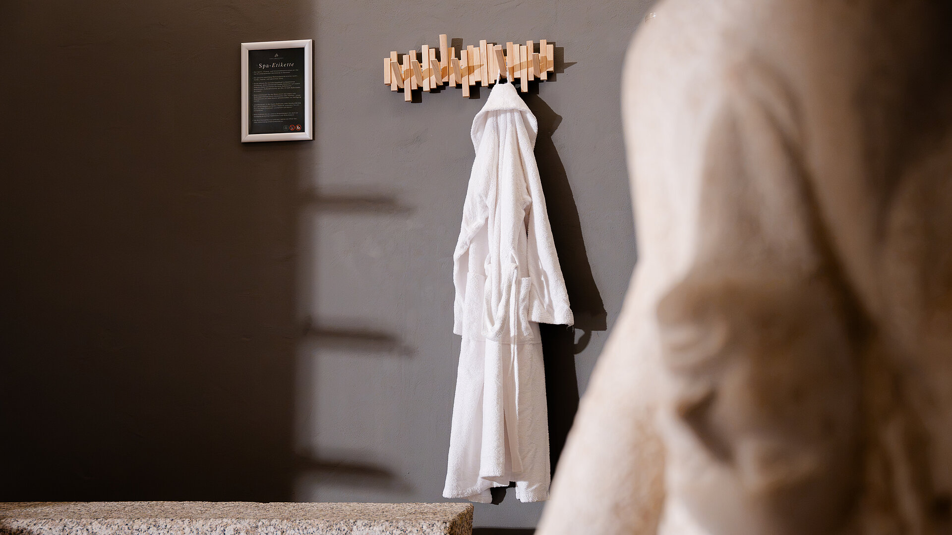 Bademantel im Saunabereich am Haken - im Vordergrund Statue