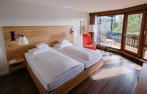 Blick auf das komfortable Doppelbett und den angrenzenden Balkon in der Superior Suite Süd.