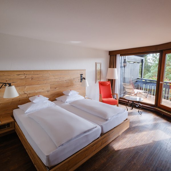 Blick auf das komfortable Doppelbett und den angrenzenden Balkon in der Superior Suite Süd.