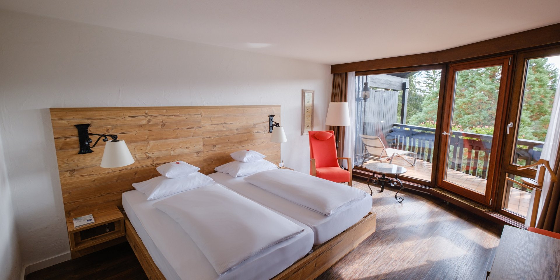 Blick auf das komfortable Doppelbett und den angrenzenden Balkon in der Superior Suite Süd.