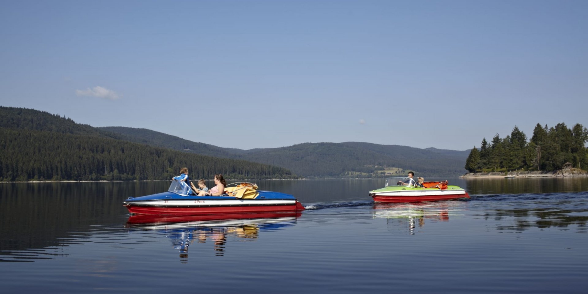 Freizeitspaß auf dem Schluchsee: Tretbootfahren vor der Schwarzwald-Kulisse.