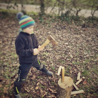 Ein Kind schnitzt konzentriert an einem Holzstock während eines Natur-Erlebnistages am Schluchsee.