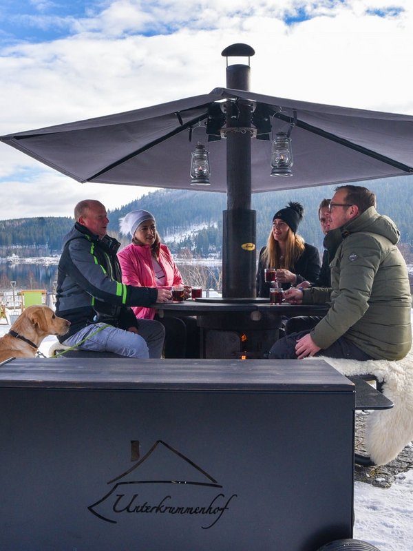 Gäste genießen die Wintersonne vor dem urigen Schwarzwaldhof Unterkrummenhof am Schluchsee.