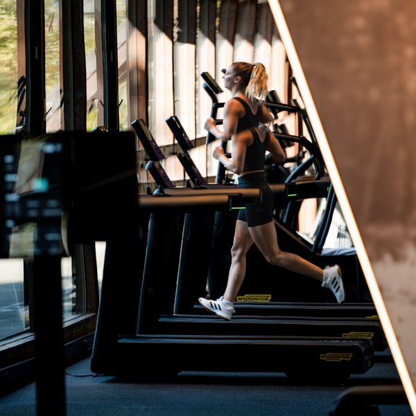 Ausdauertraining im Hotel Vier Jahreszeiten am Schluchsee: Eine Frau läuft auf einem modernen Laufband.