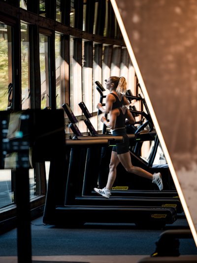 Ausdauertraining im Hotel Vier Jahreszeiten am Schluchsee: Eine Frau läuft auf einem modernen Laufband.