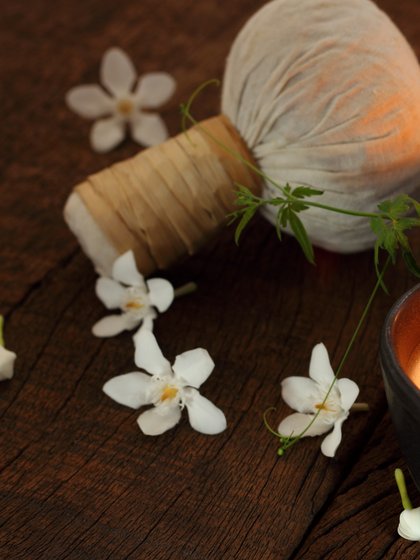 Ein Krätuerstempel liegt umradet von Blumen auf einem Tisch