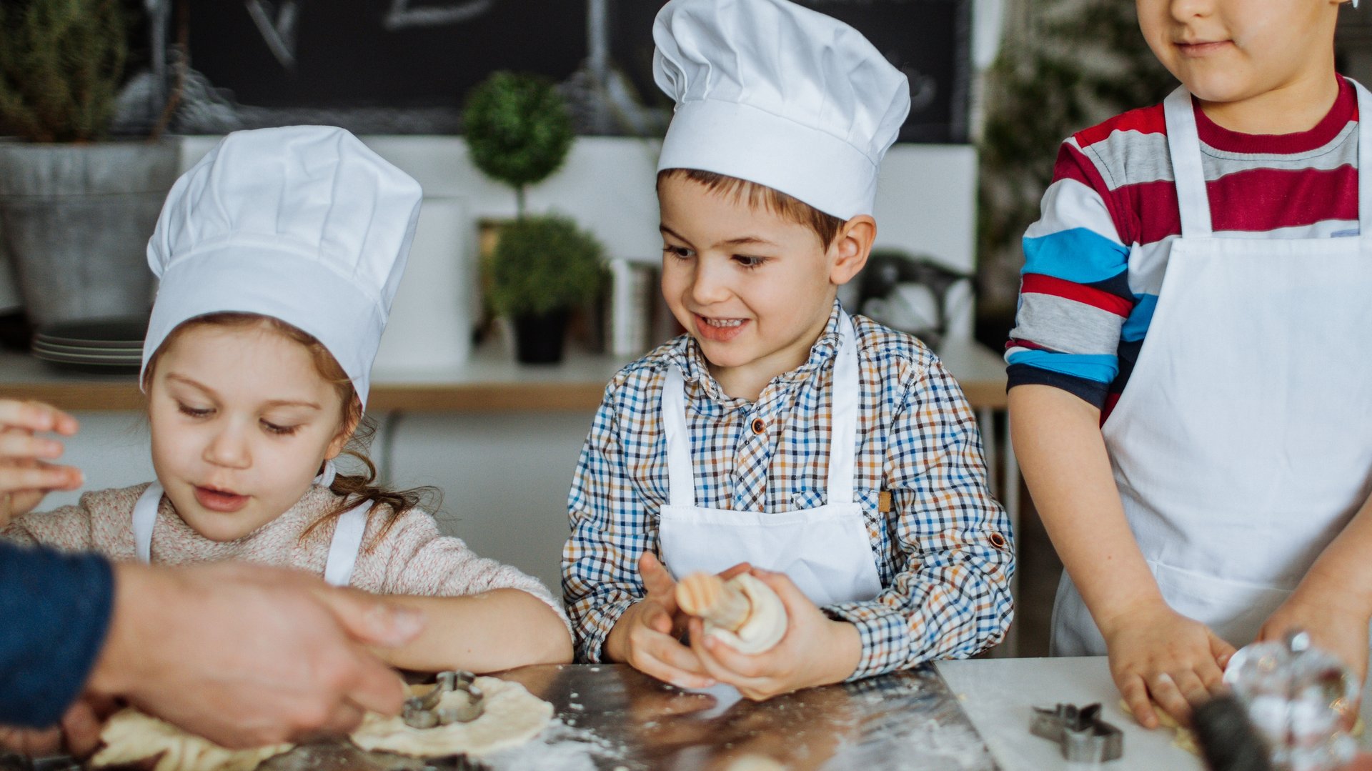drei Kinder in einer Küche am kochen 