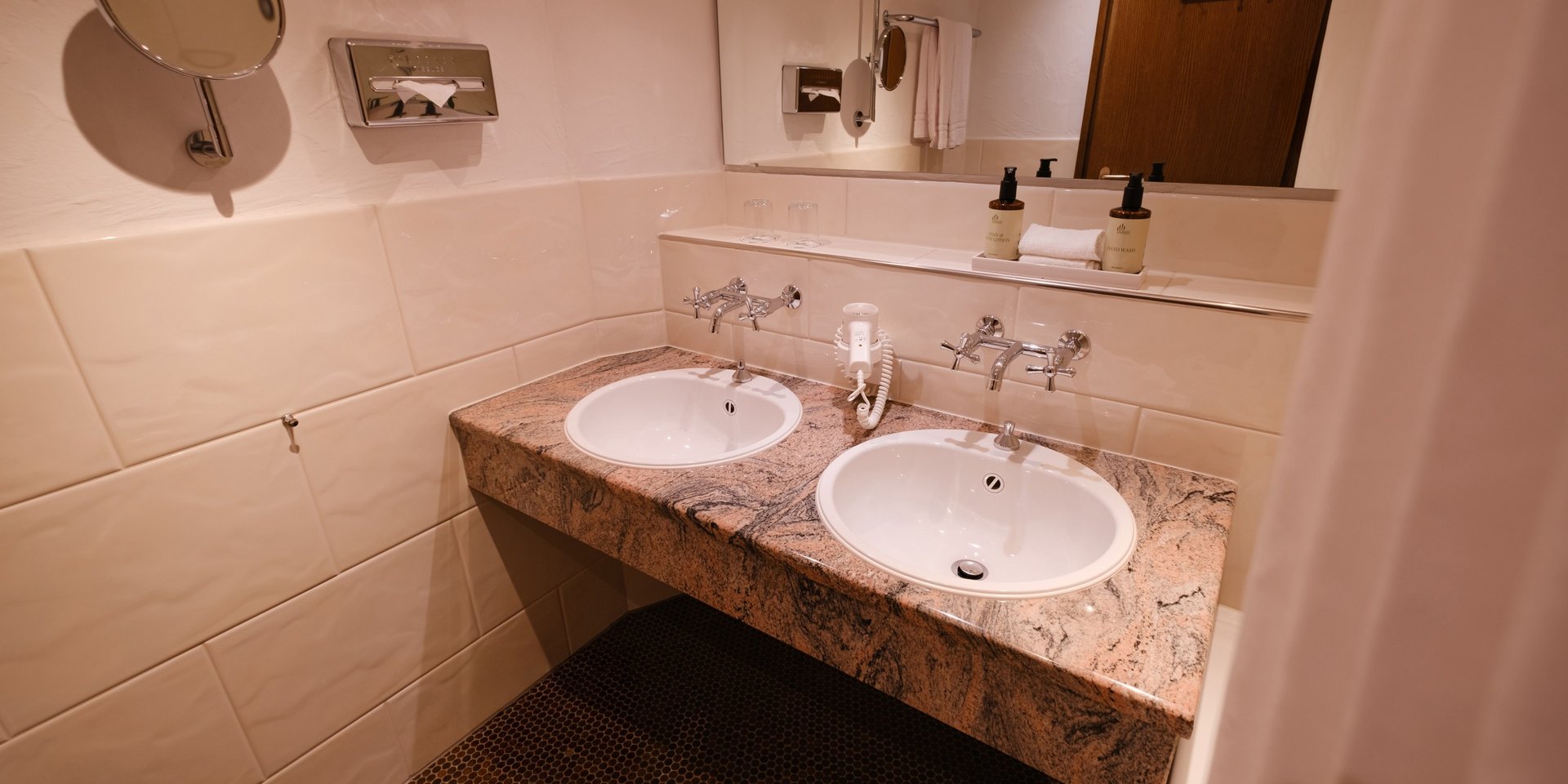 Detailansicht des Doppelwaschtischs mit Marmor-Optik und Wandspiegel.