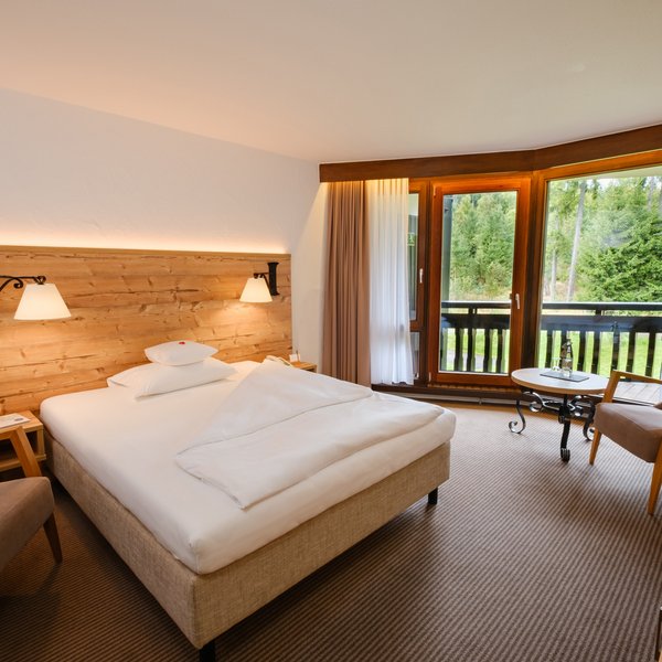 Helles Einzelzimmer Klassik Wald mit geräumigem Bett und gemütlicher Sitzecke im Hotel Vier Jahreszeiten am Schluchsee.