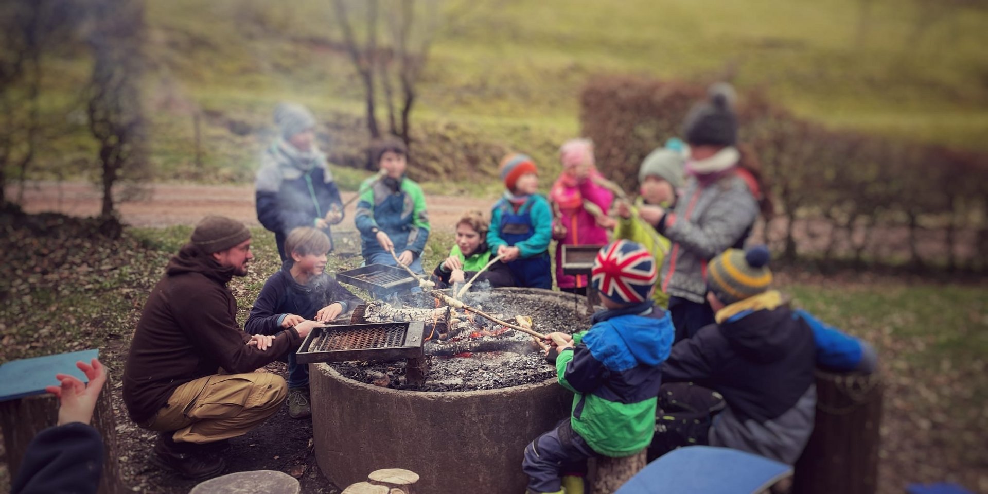 Eine Gruppe sitzt gemütlich am Lagerfeuer und lässt den Tag bei einem Workshop im Schwarzwald ausklingen.