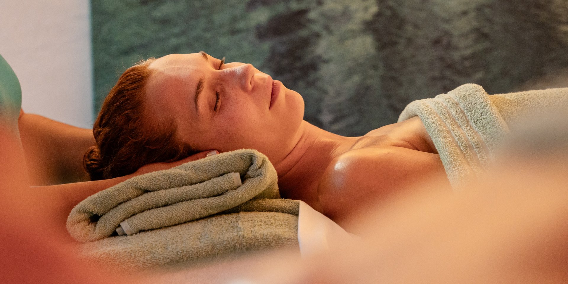 Ruhemoment während einer Kopfbehandlung bei einem zugedeckten Gast im Hotel Vier Jahreszeiten.