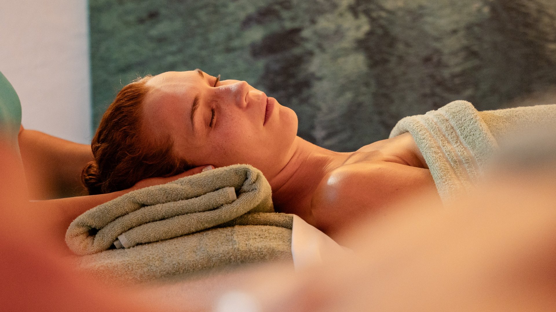 Ruhemoment während einer Kopfbehandlung bei einem zugedeckten Gast im Hotel Vier Jahreszeiten.