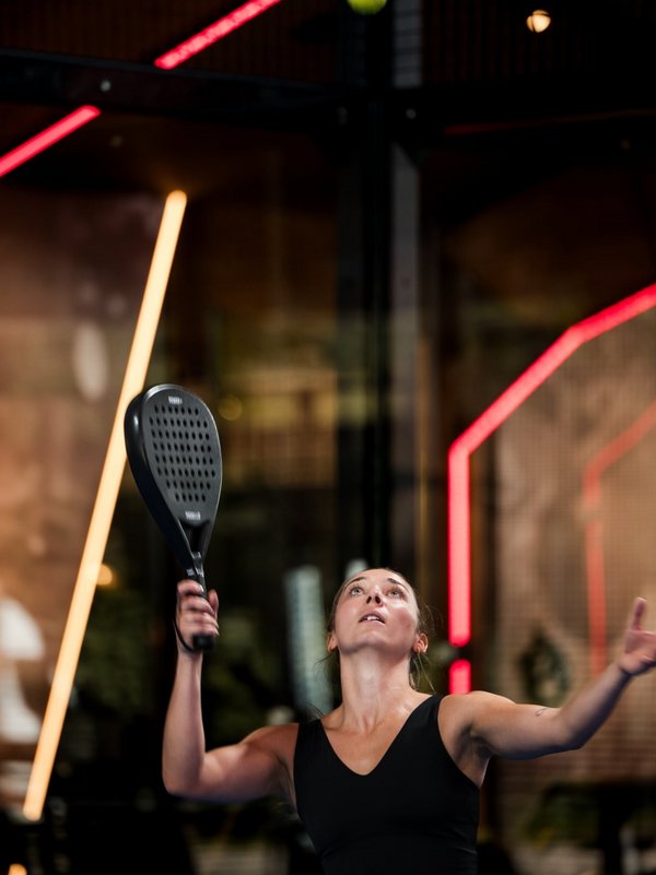 Eine Spielerin beim Aufschlag während einer Padel-Session im Hotel Vier Jahreszeiten am Schluchsee.