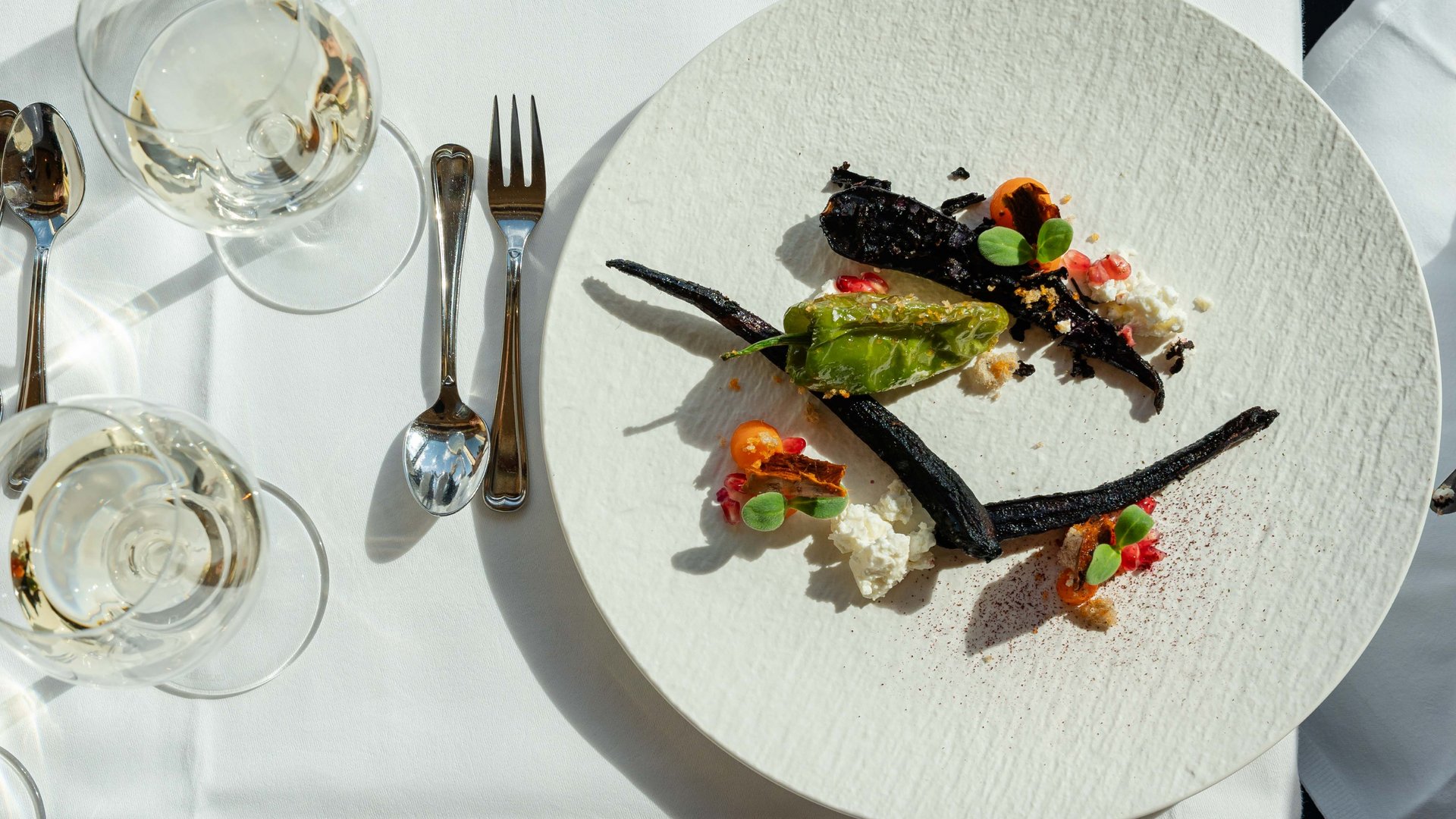 Exquisiter Hauptgang mit dunklen Akzenten und feinem Gemüse im Hotel Vier Jahreszeiten am Schluchsee.