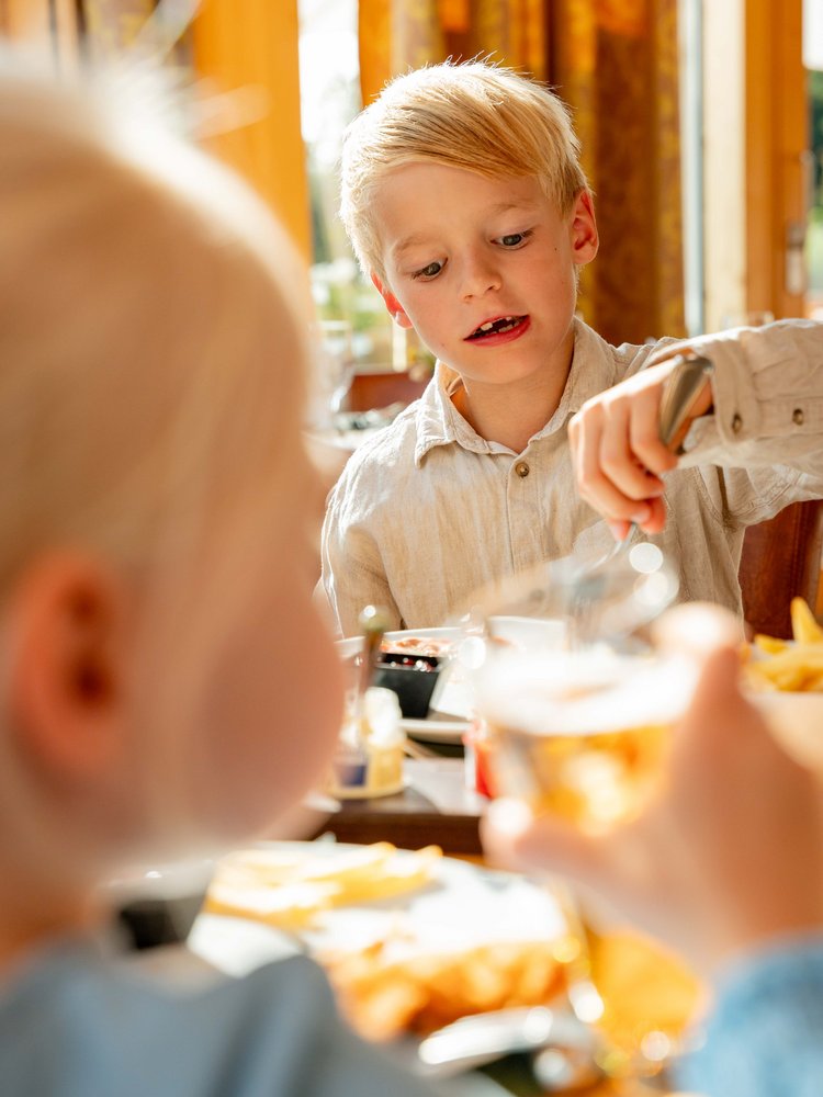 Kinder genießen sichtlich ihr Getränk und die helle Atmosphäre im Hotel Vier Jahreszeiten am Schluchsee.