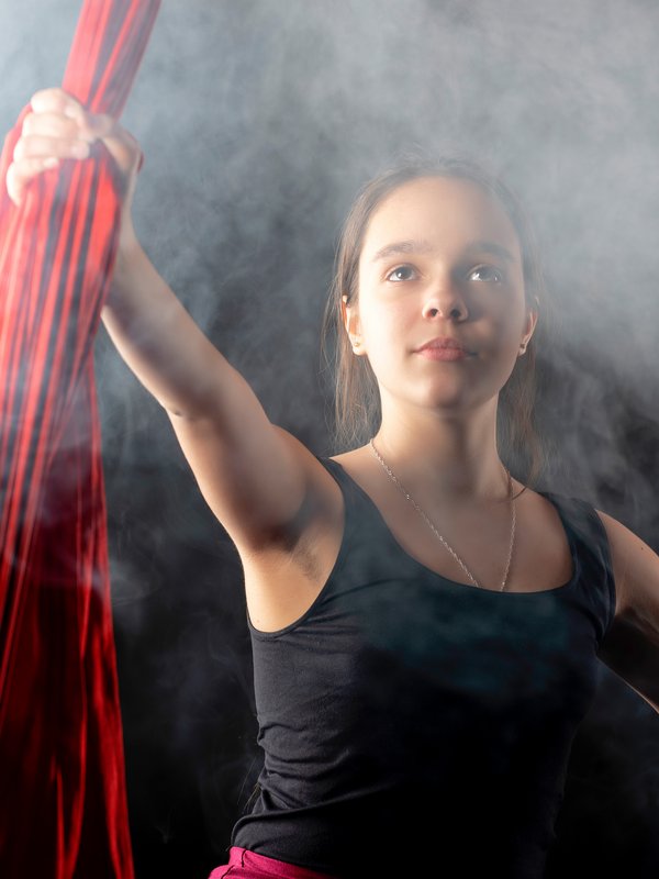 Mädchen mit Hand an Seiltüchern im Zirkus