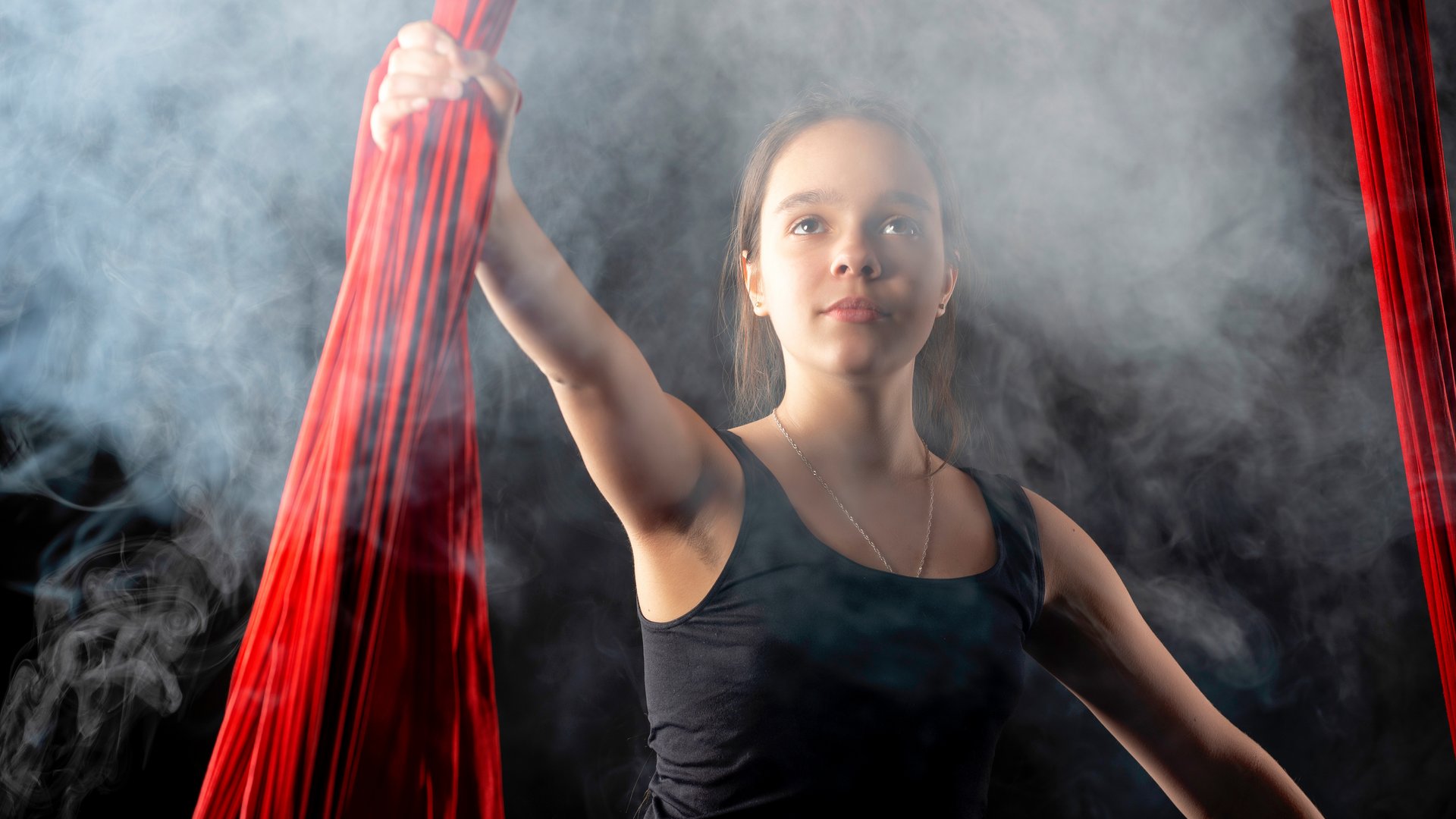 Mädchen mit Hand an Seiltüchern im Zirkus