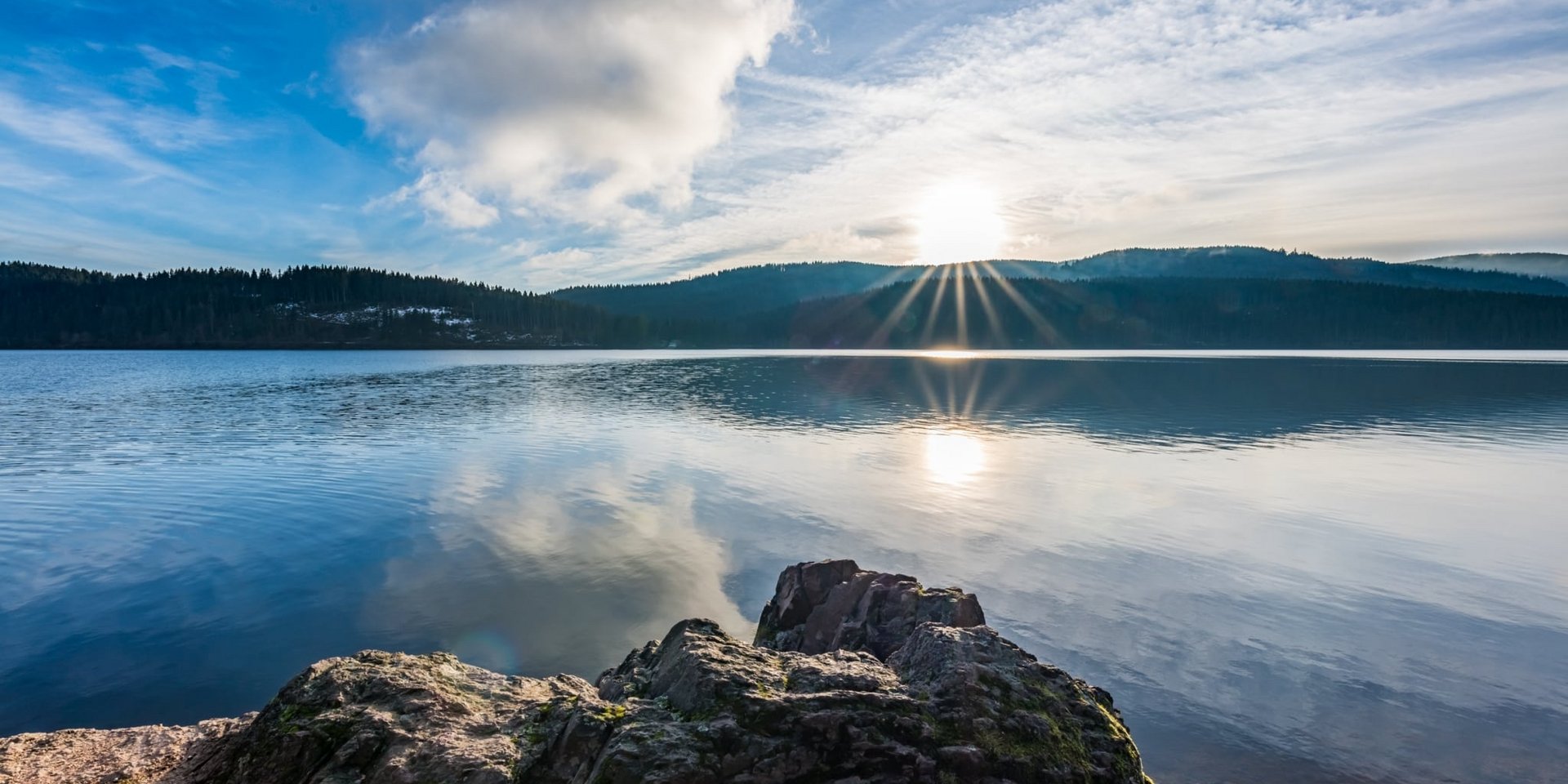 Panoramablick über den ruhigen Schluchsee im Schwarzwald bei klarem Wetter.