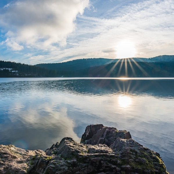 Panoramablick über den ruhigen Schluchsee im Schwarzwald bei klarem Wetter.