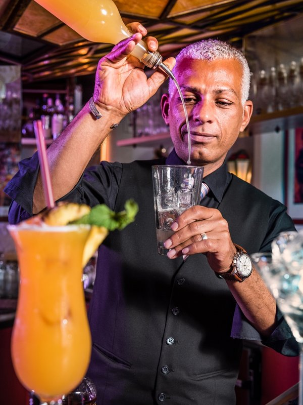 Ein professioneller Barkeeper bereitet an der Bar des Hotels Vier Jahreszeiten am Schluchsee einen Cocktail zu.