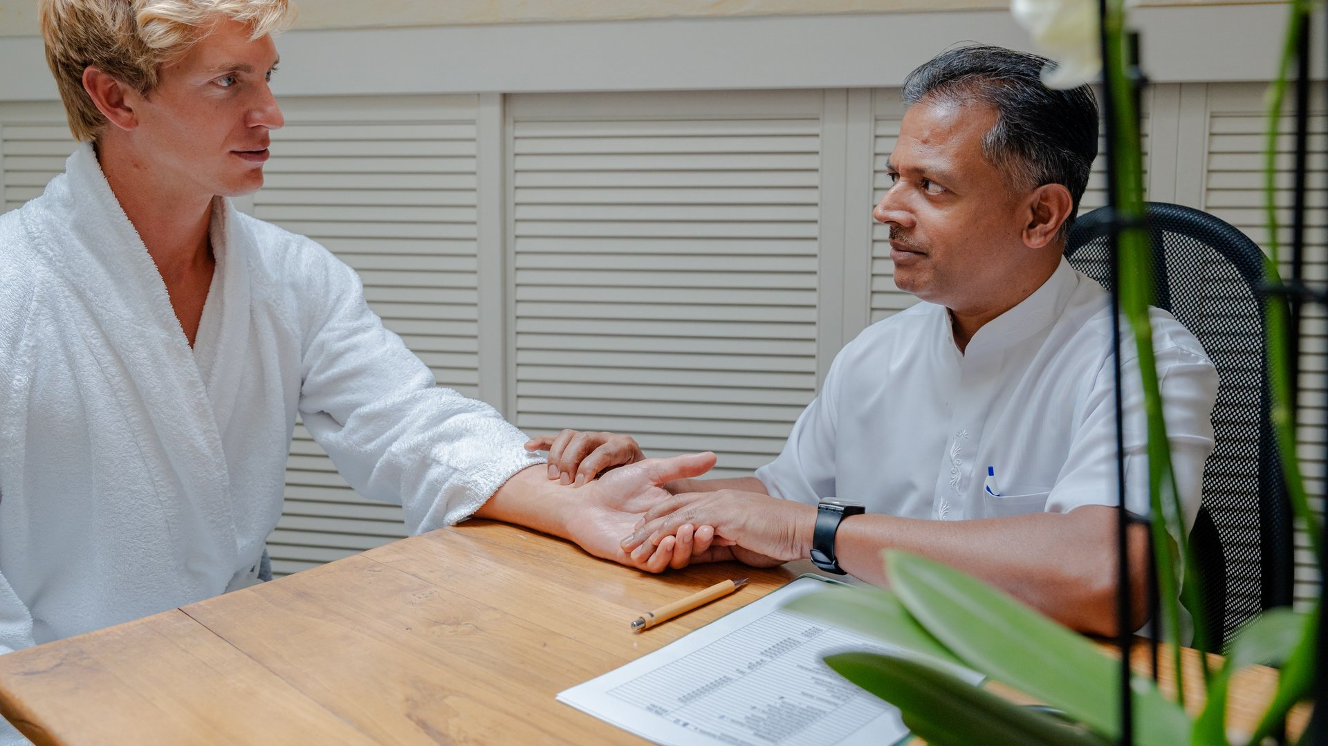 Beratungsgespräch und Pulsdiagnose bei einem Experten in der Ayurveda-Abteilung des Hotels Vier Jahreszeiten.