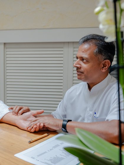 Beratungsgespräch und Pulsdiagnose bei einem Experten in der Ayurveda-Abteilung des Hotels Vier Jahreszeiten.